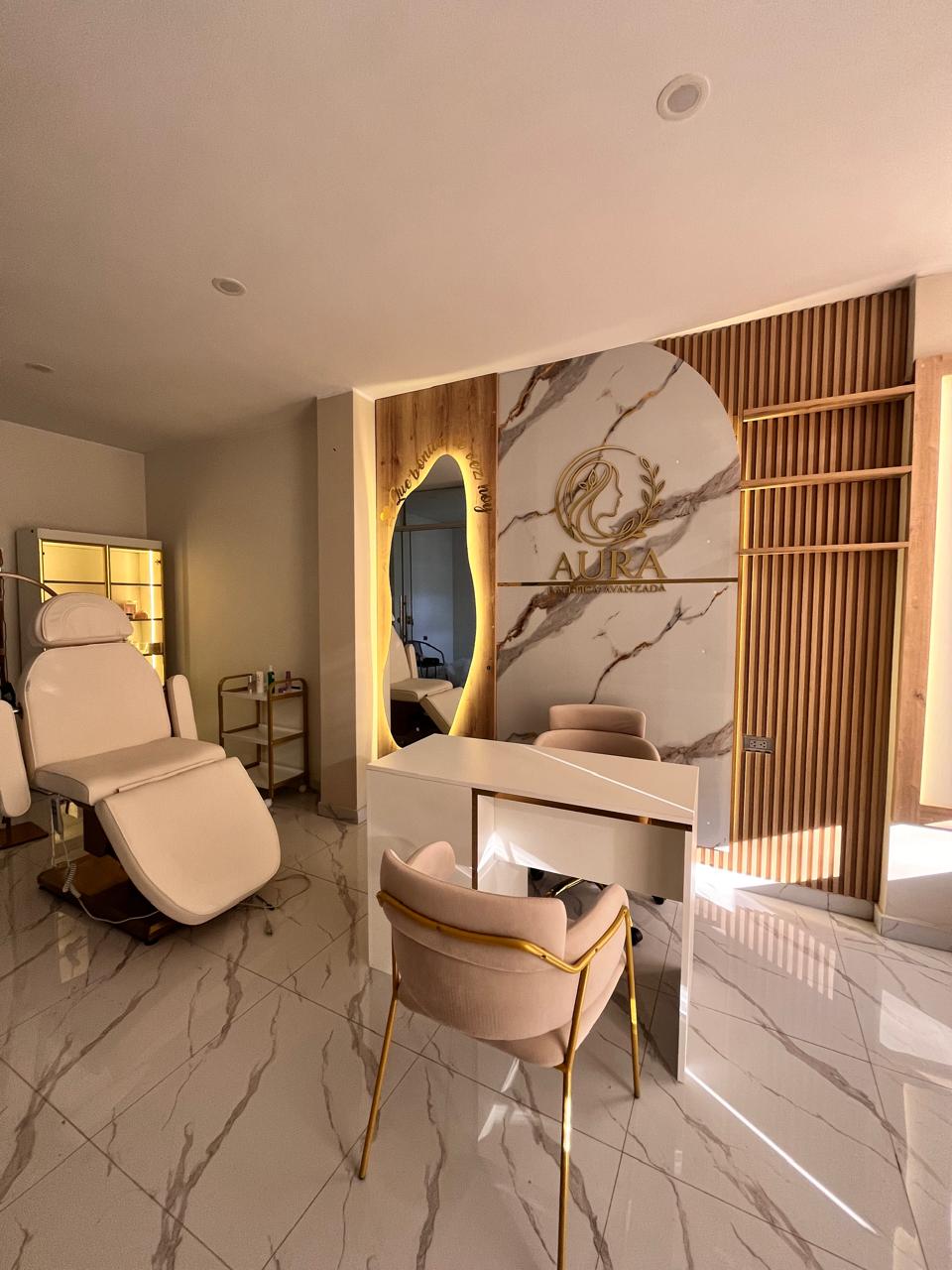 Interior de Aura con sillón de atención, escritorio y pared con el logotipo de la clínica